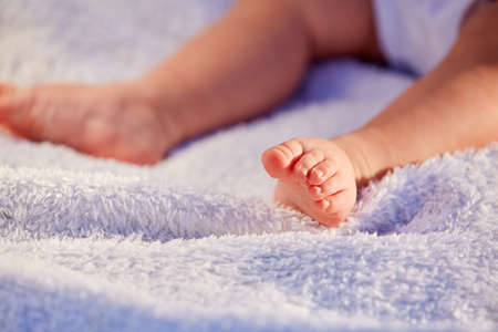 Closeup legs of little girl on soft pillowの写真素材