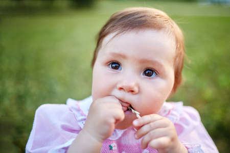 Sweet Beautiful little girl outdoors looking to the camera. Joyful, Happy, Excited. Closeup Portraitの写真素材