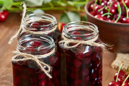 Cherry jam on wooden ground with fresh cherries