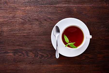 Green tea with lemon and mint on wooden table background with copy space
