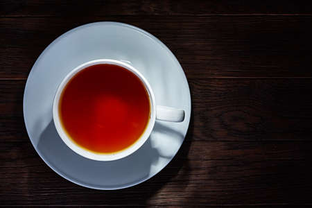 Cup of tea on a dark wooden background top viewの写真素材