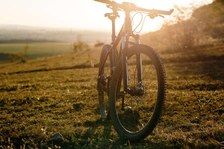 Silhouette of Mountain bike on the meadow at sunsetの写真素材