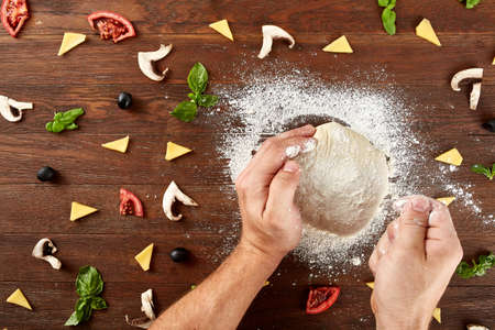 hands knead the dough for pizza makingの写真素材