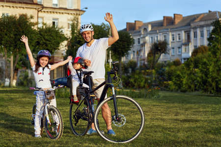 Cheerful family biking in parkの写真素材