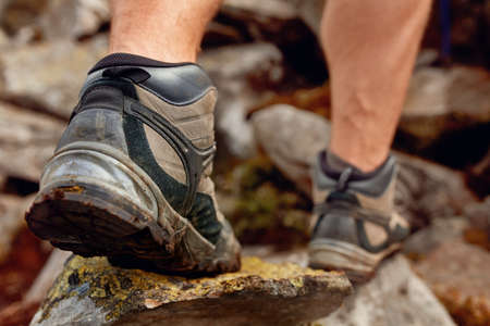 Hiking man with trekking boots on the trailの写真素材