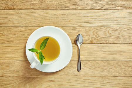 Cup with tea and teapot on wooden backgroundの写真素材