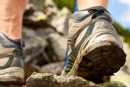 Hiking man with trekking boots on the trailの写真素材