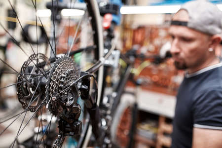 Bicycle mechanic in a workshop in the repair process