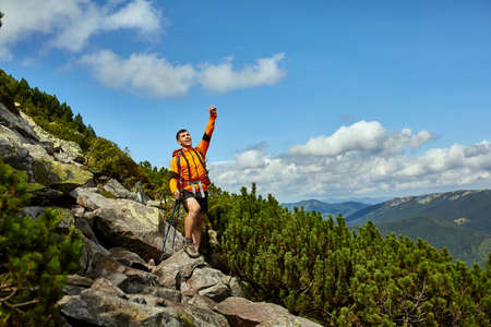 Hiker cheering elated and blissful with arms raised in the sky after hiking