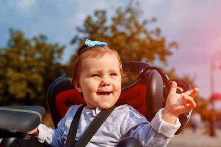 cute happy little baby on bike seat cycling in city parkの写真素材