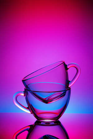 Two cups and saucers of glass. Tea is poured into the top Cup. Helium filter gives a beautiful light.の写真素材