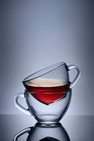 Two cups and saucers of glass. Tea is poured into the top Cup. Helium filter gives a beautiful light.の写真素材