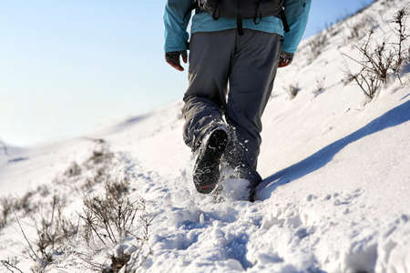 Person hiking on the mountaintop covered with snow low angle view