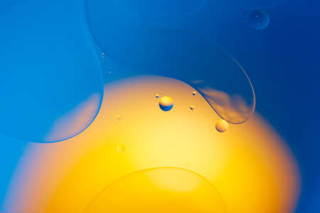 Mixing water and oil, beautiful color abstract background based on red and yellow circles and ovals,...