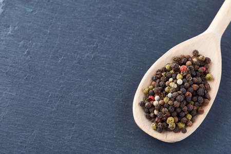 black pepper peas in a spoon on a stone backgroundの写真素材