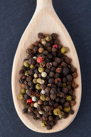 black pepper peas in a spoon on a stone backgroundの写真素材