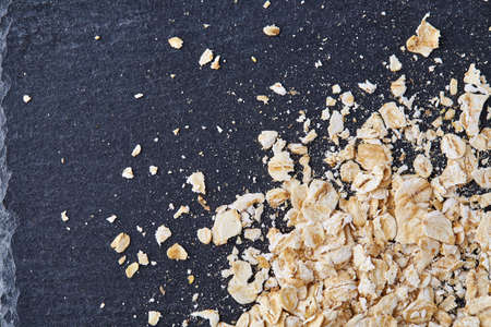 Yellow oats pyramid positioned in the corner on a black stone backgroundの写真素材