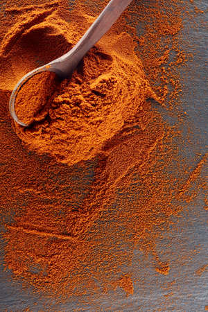 Texture background. Red chilli pepper powder mixed with wooden spoon. Top viewの写真素材