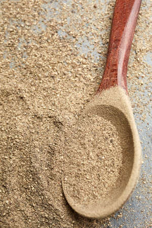 Top view of a wooden spoon full of grind black pepper, shallow depth of field.の写真素材