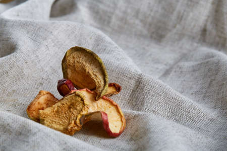 Top view close-up picture of dried apples on light grey cotton tablecloth, copy space, selective focus. Healthy and yummy snack. Healthy lifestyle concept.の写真素材