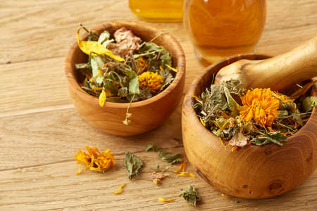 Beautiful composition of two transparent glass oil jars, wooden mortar and pestle with flax seeds and a scoop on wooden table, shallow depth of field, close-up. Overhead view of kitchen utensils and ingredients on wooden tableの写真素材