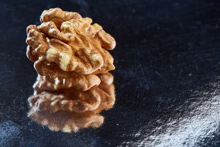 Top view close-up picture of nutritious tasty dry cracked walnuts on dark background, shallow depth of field, selective focus, macro. Seasonal nuts. Oilrich food. Healthy lifestyle concept.の写真素材