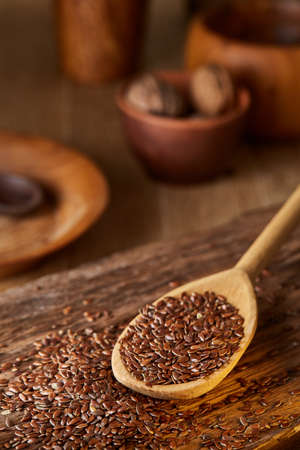 Wooden spoon with flax seeds on rustic background, top view, close-up, shallow depth of field, selective focusの写真素材