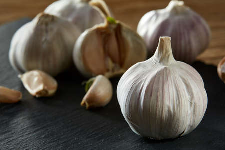 Garlic close up on wooden plate on rustic background, shallow depth of field, selective focus, macroの写真素材
