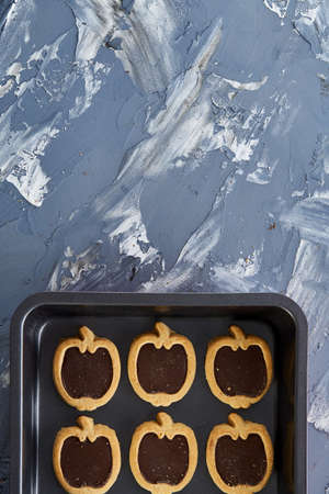 Fresh baked chocolate apple shaped cookies on a cookie sheet, top view, close-up, selective focusの写真素材