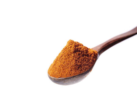 Top view of a wooden spoon full of paprica isolated on white background, shallow depth of field.の写真素材