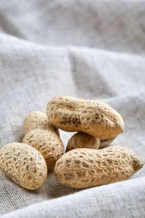 Heap of peanuts on light tablecloth, close-up, shallow depth of field, selective focus, macroの写真素材