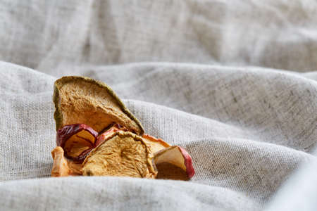 Top view close-up picture of dried apples on light cotton tablecloth, selective focus.の写真素材