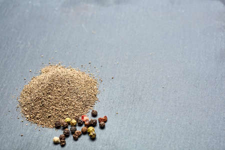 Close-up top view picture of heap of raw natural unprocessed red, white, yellow and black allspice...