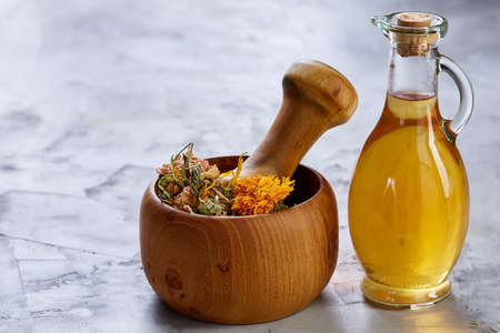 Spa still life with flowers in wooden bowl and two oil jars on light textured background, top view, close-up, selective focus. Alternative medicine. Spa natural concept. Dayspa cosmetics products. Spa and wellness setting. spa decoration conceptの写真素材