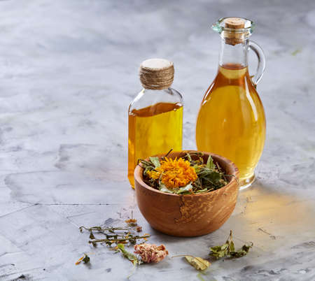 Spa still life with flowers in wooden bowl and two oil jars on light textured background, top view, close-up, selective focus. Alternative medicine. Spa natural concept. Dayspa cosmetics products. Spa and wellness setting. spa decoration conceptの写真素材