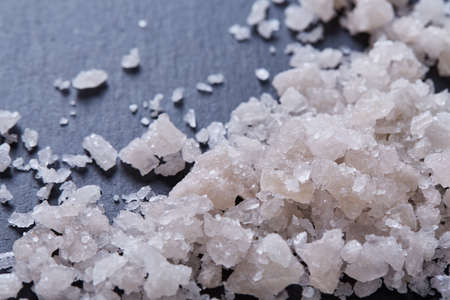 Pile of salt crystals isolated over the dark background, close-up,top,view, selective focus. Some...