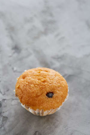 Tasty vanilla muffins arranged in pattern on light textured background, top view, close-up, shallow...