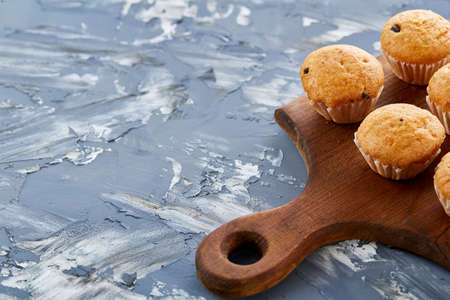 Top view close-up picture of tasty muffins on the cutting board over light abstract background, shallow depth of field, selective focus. Yummy homemade snack. Delicious pastry. Breakfast background.の写真素材