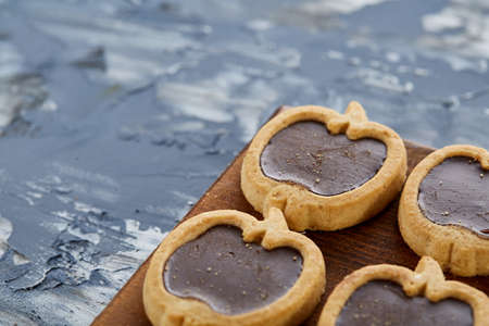 Top view close-up picture of tasty apple-shaped cookies on the cutting board over light abstract background, shallow depth of field, selective focus. Yummy homemade snack. Delicious pastry. Breakfast background.の写真素材