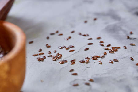 Flax seeds in wooden bowl and spoon on rustic wooden background, top view, shallow depth of fieldの写真素材