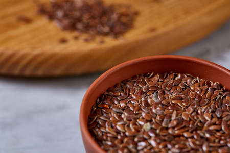 Flax seeds in wooden bowl and spoon on rustic wooden background, top view, shallow depth of fieldの写真素材