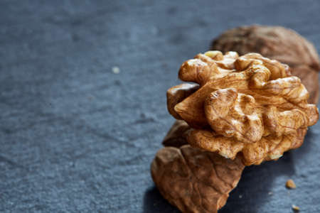 Top view close-up shot of cracked walnuts on dark background, shallow depth of field, macroの写真素材