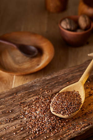 Wooden spoon with flax seeds on rustic background, top view, close-up, shallow depth of field, selective focusの写真素材