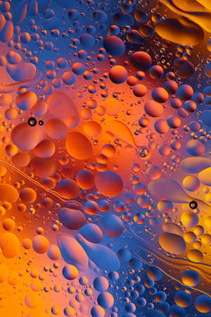 Mixing water and oil, beautiful color abstract background based on red and yellow circles and ovals,...