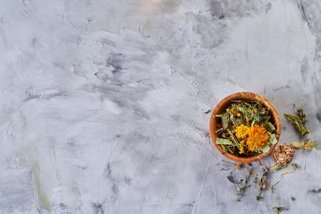 Spa still life with flowers in wooden bowl on light textured background, top view, close-up, selective focusの写真素材