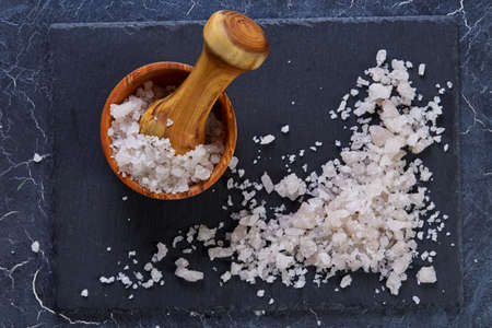 Pile of salt crystals mixed with motley grass on the dark background, close-up, top view, macro, selective focusの写真素材