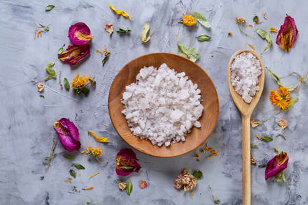 Composition of spa treatment on white background. Sea salt and flowers background, close up, top view, selective focus.の写真素材