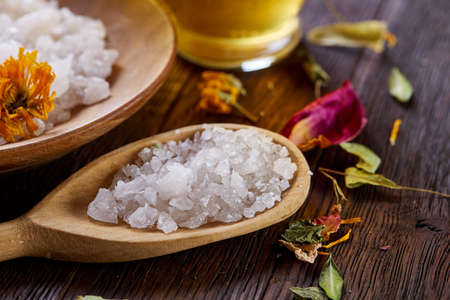 SPA concept: composition of spa treatment with natural sea salt, aromatic oil and flowers on wooden backgroundの写真素材
