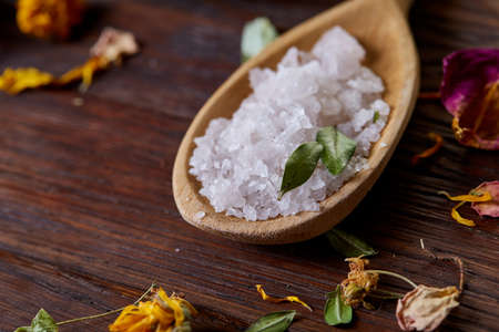 SPA concept: composition of spa treatment with natural sea salt, aromatic oil and flowers on wooden backgroundの写真素材