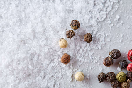 Composition of bay laurel leaf with peppercorn and salt isolated on dark background, top view, close-up, selective focusの写真素材
